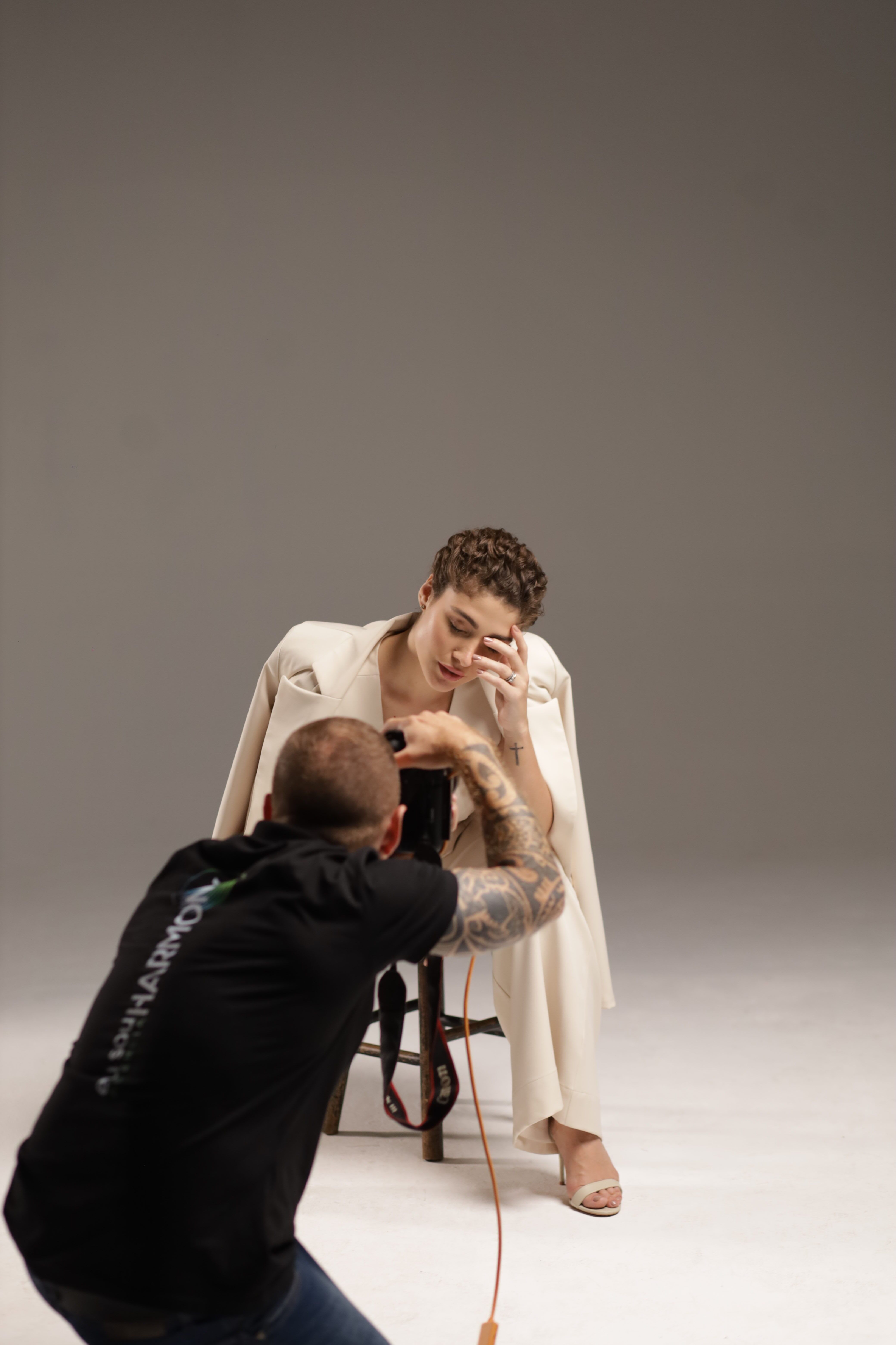 Elegant fashion model posing during a professional studio photoshoot with a photographer