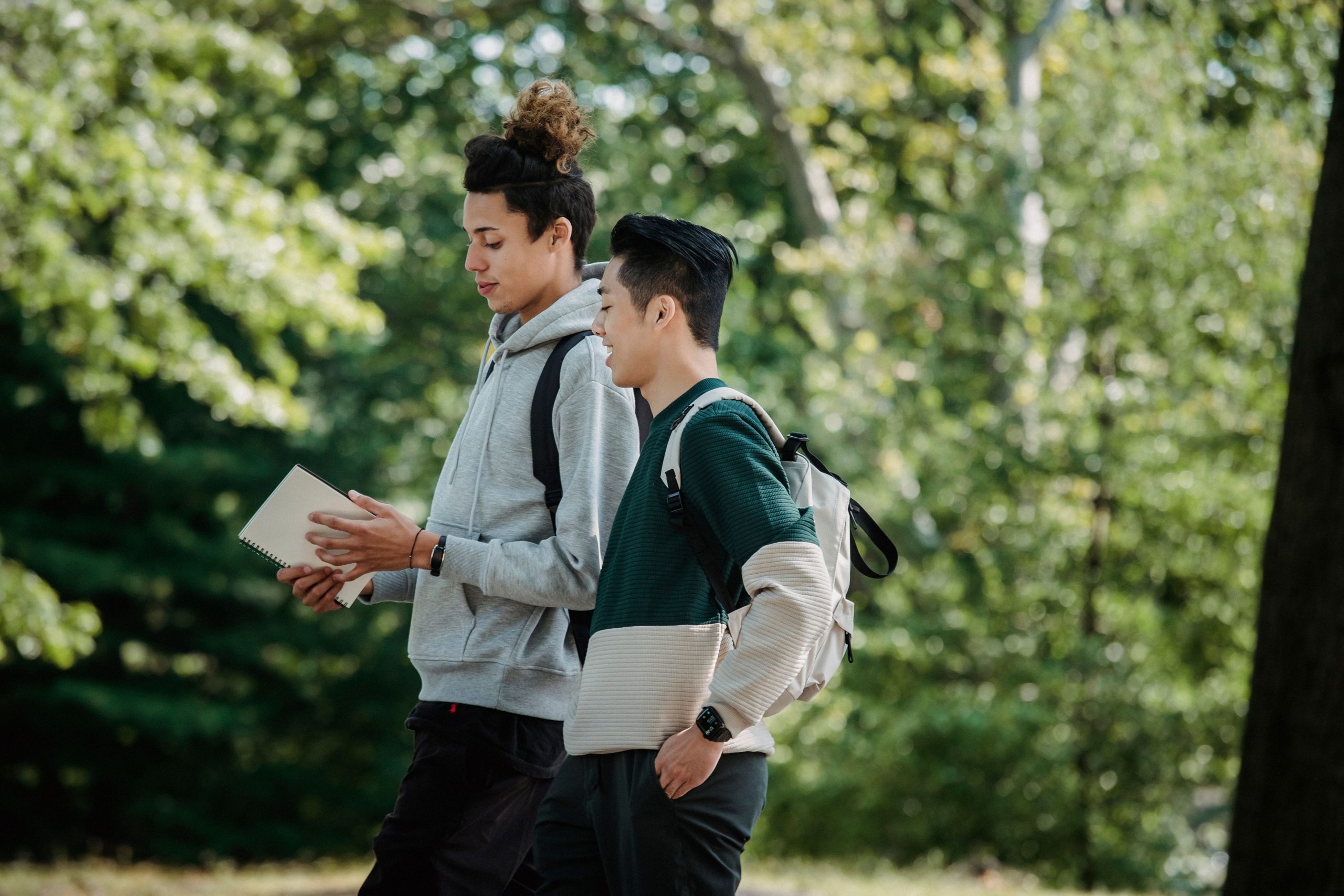 Multiethnic university students with backpacks walking through campus, a common target for talent scouts