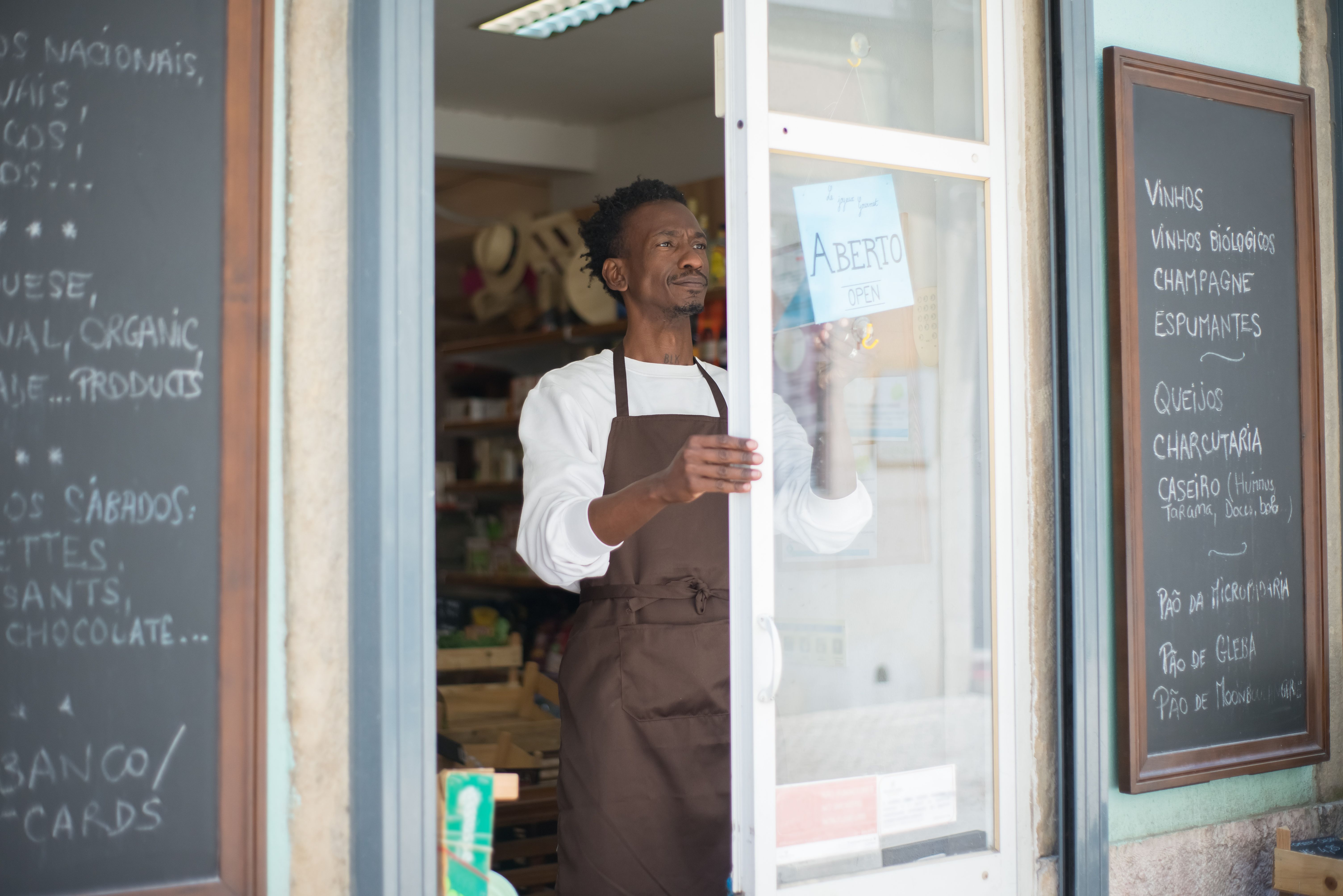 Local shop owner in an apron opening his grocery store, a small business trying to get found online