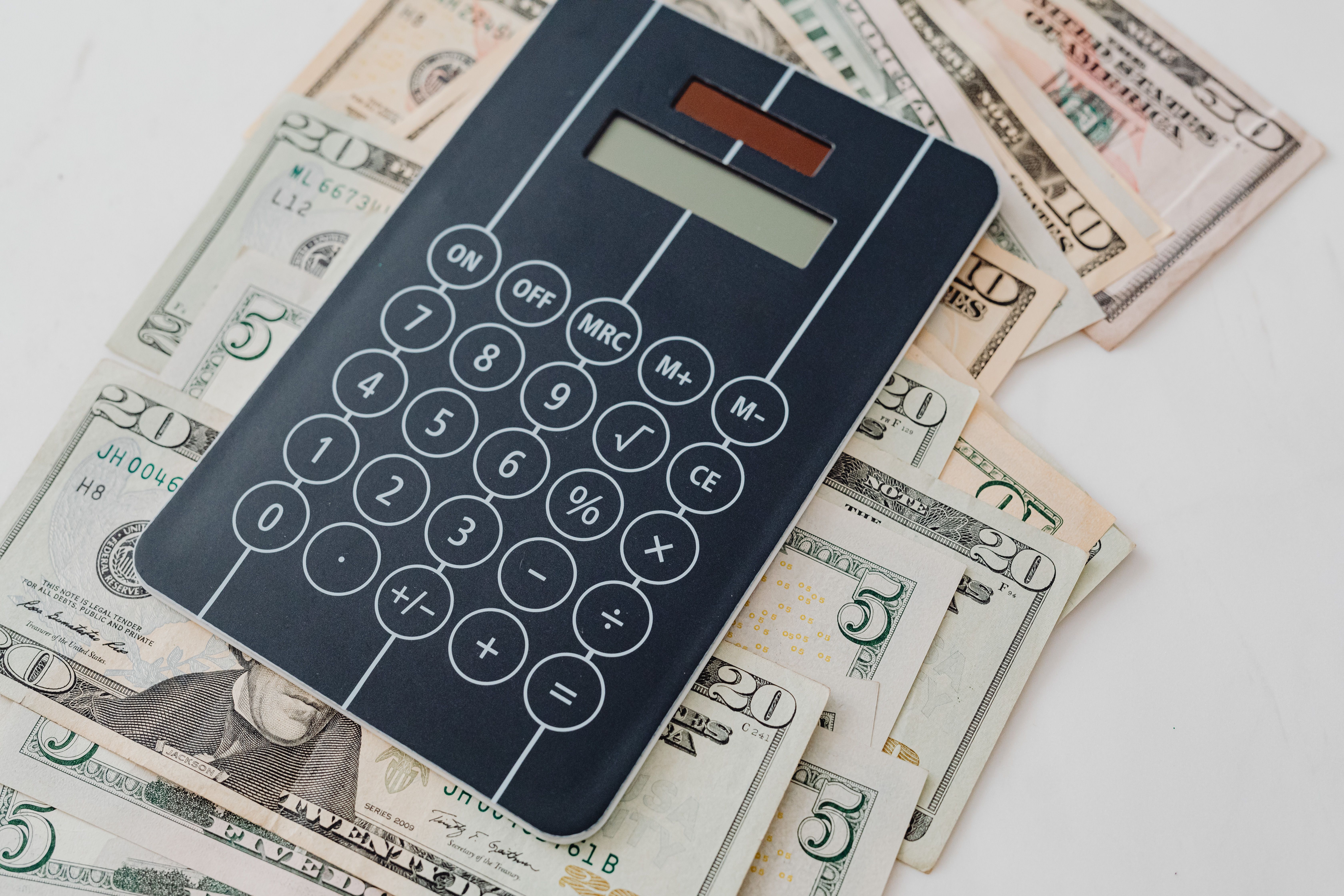 Calculator resting on US dollar bills representing the monthly cost of SEO services