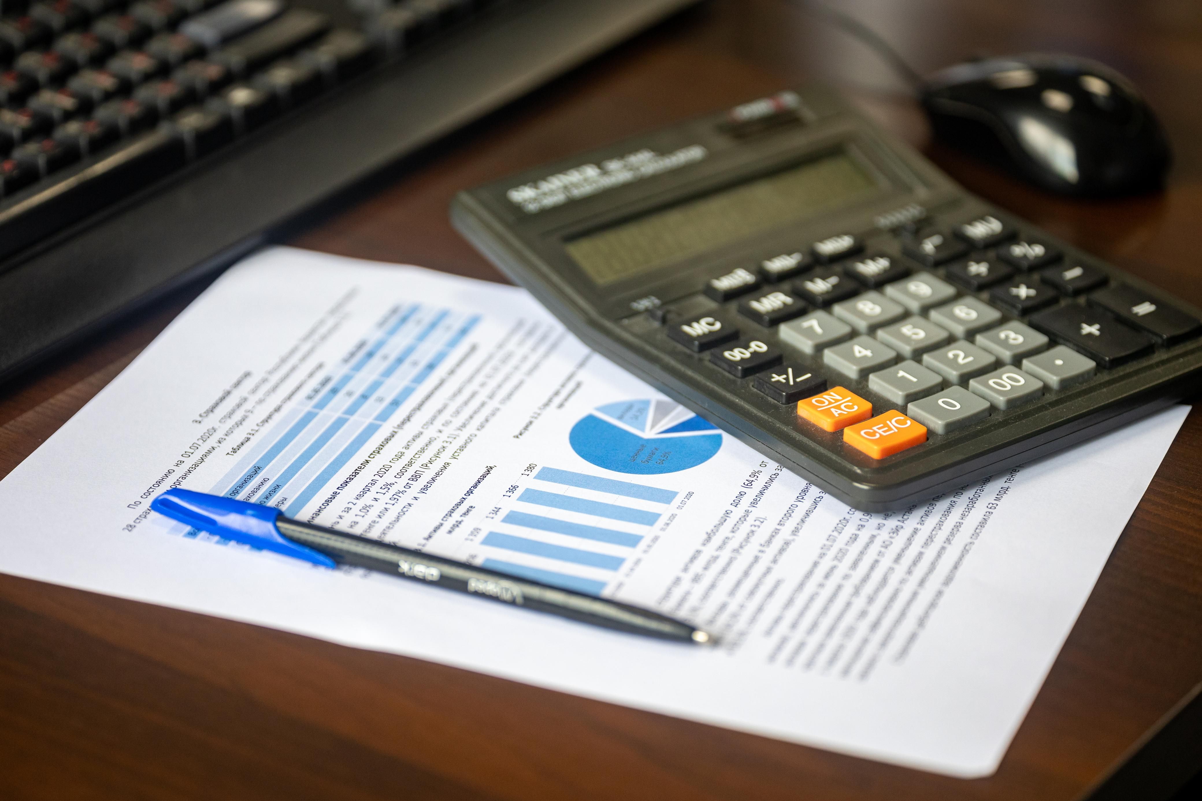 Desk with calculator, financial report, and pen representing law firm financial management