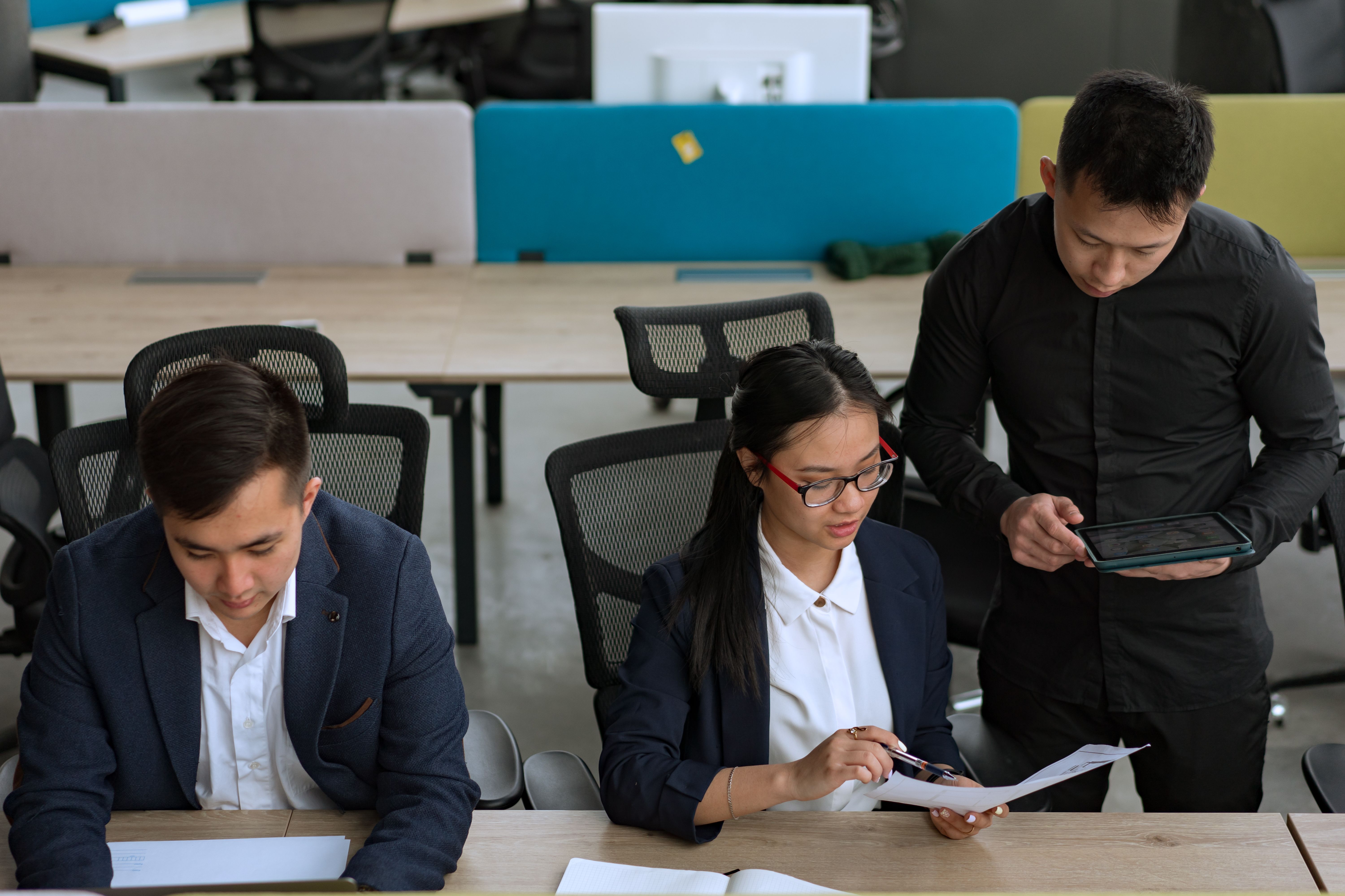 Professional team collaborating around documents and technology in a modern office